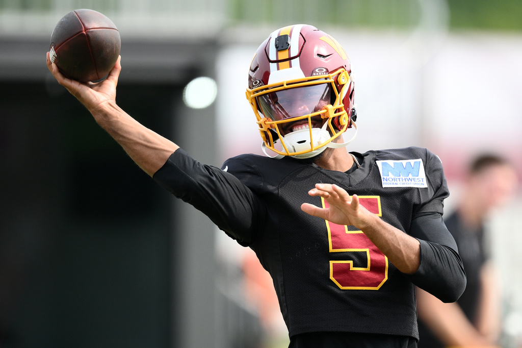 Washington Commanders quarterback Jayden Daniels works out before a joint practice with the Miami Dolphins at NFL football training camp, Wednesday, Aug. 12, 2026 in Ashburn, Va. (AP Photo/Nick Wass)