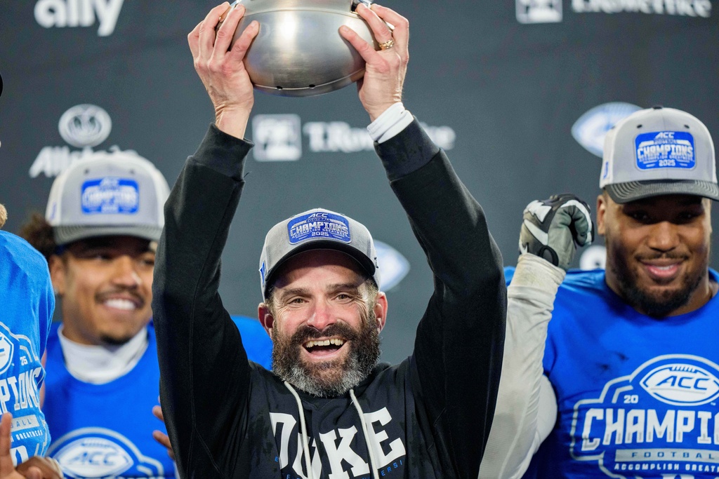 Duke head coach Manny Diaz holds up the trophy after defeating Virginia in the Atlantic Coast Conference championship NCAA college football game Saturday, Dec. 6, 2025, in Charlotte, N.C. (AP Photo/Jacob Kupferman)