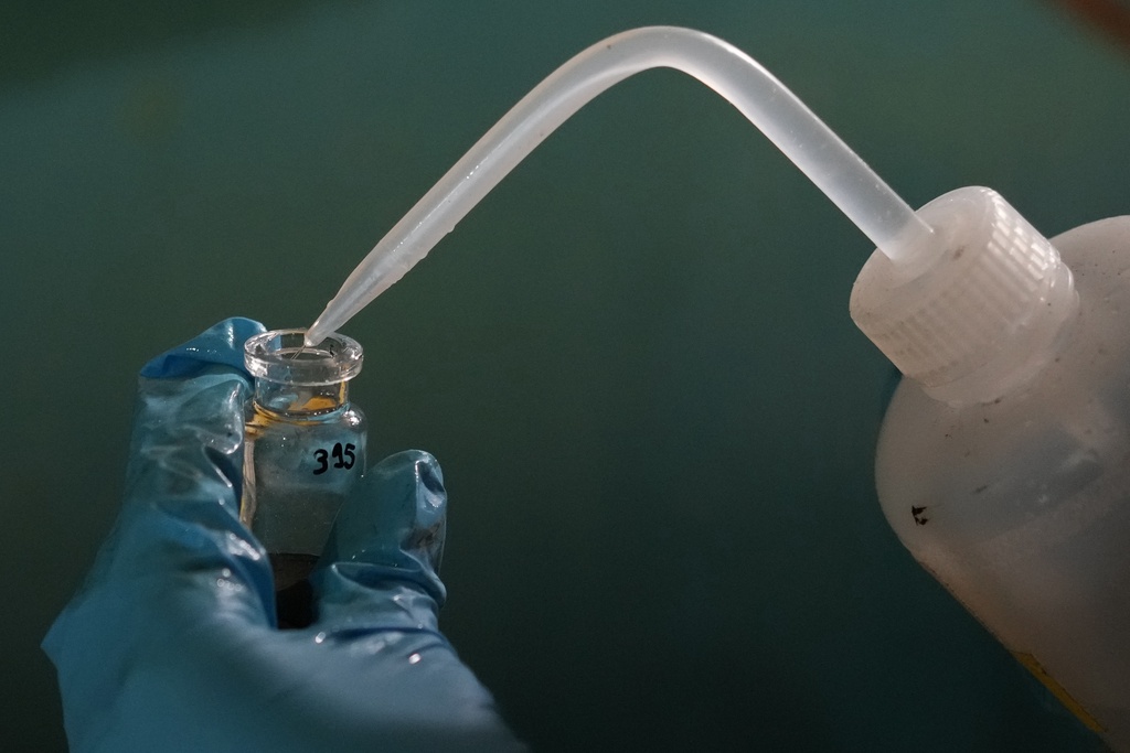 Expedition 501 researcher Jack Brickell prepares a sample vial for analysis aboard the Liftboat Robert platform in the North Atlantic, Sunday, July 20, 2025. (AP Photo/Carolyn Kaster)