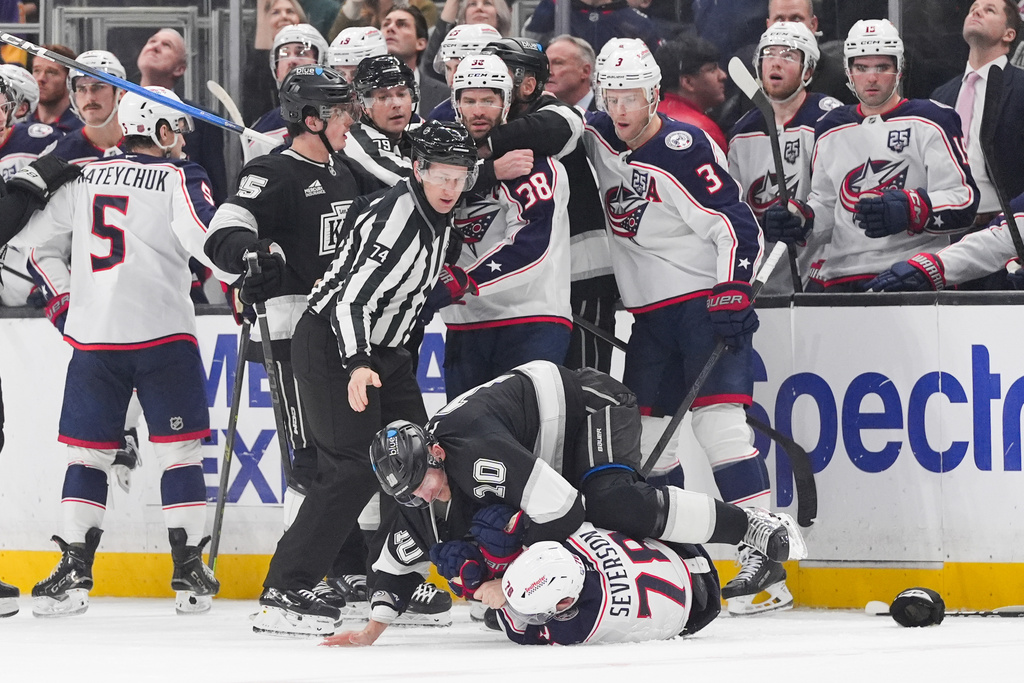 Columbus Blue Jackets defenseman Damon Severson (78) is pinned to the ice by Los Angeles Kings right wing Corey Perry (10) during the second period of an NHL hockey game Monday, Dec. 22, 2025, in Los Angeles. (AP Photo/Jae C. Hong)
