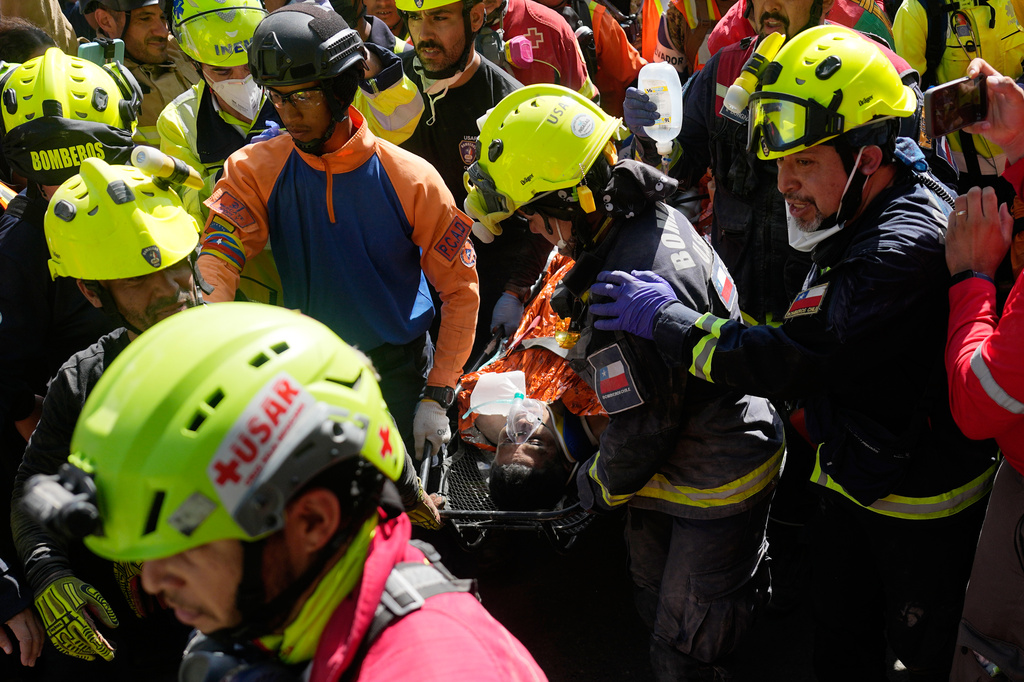 Rescue workers carry Hernán Alberto Gil Flores Gil after he was pulled from the rubble eight days after he was trapped by twin earthquakes that struck Catia La Mar, Venezuela, Thursday, July 2, 2026. (AP Photo/Fernando Vergara)