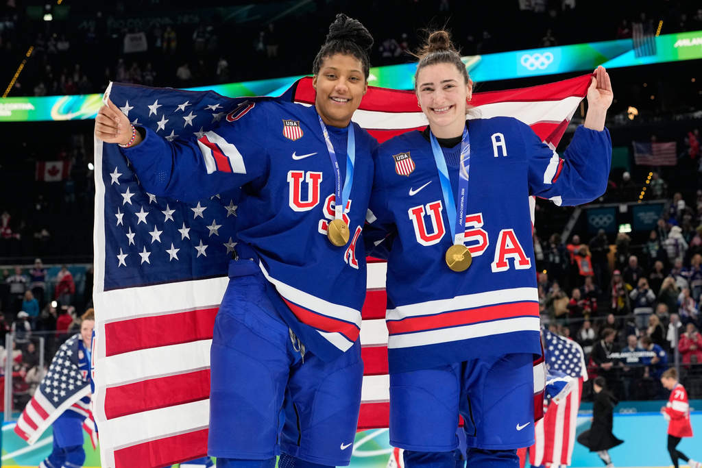 United States' Laila Edwards, left, and United States' Megan Keller celebrate after victory ceremony for women's ice hockey at the 2026 Winter Olympics, in Milan, Italy, Thursday, Feb. 19, 2026. (AP Photo/Hassan Ammar)