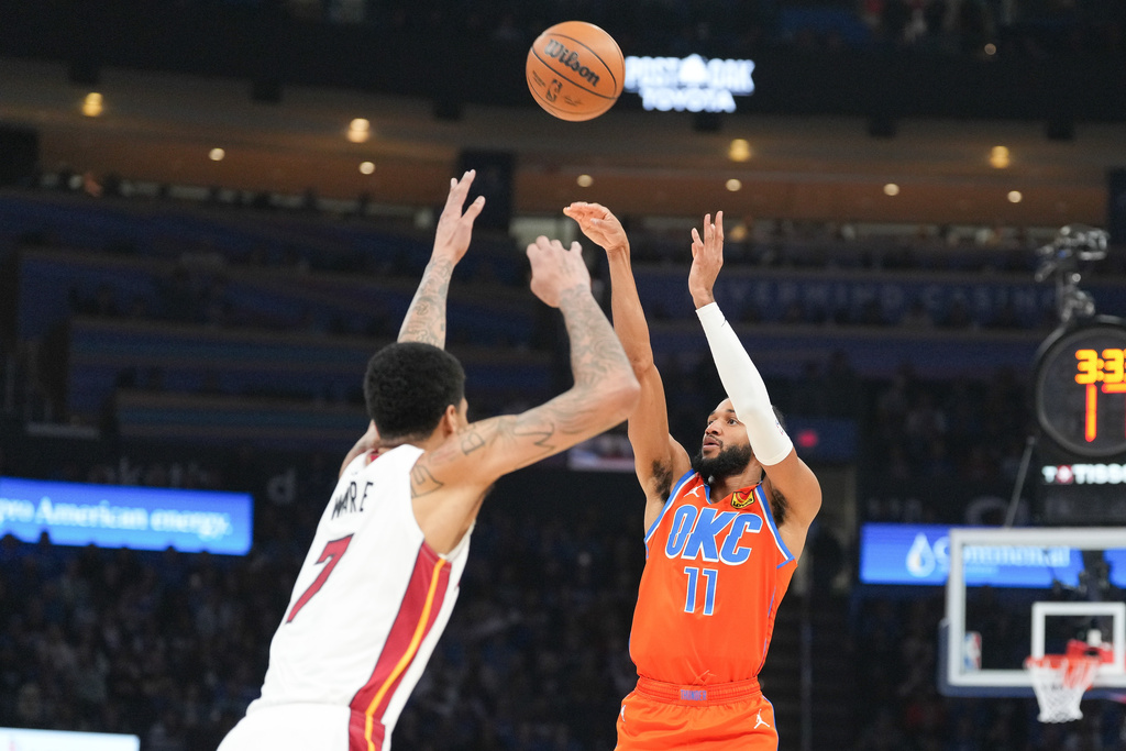 Oklahoma City Thunder guard Isaiah Joe (11) shoots over Miami Heat center Kel'el Ware (7) during the second half of an NBA basketball game, Sunday, Jan. 11, 2026, in Oklahoma City. (AP Photo/Kyle Phillips)