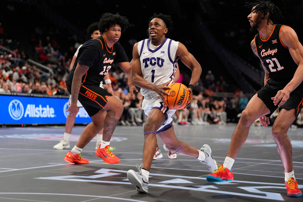 TCU's Jayden Pierre (1) heads to the basket past Oklahoma State's Mekhi Ragland (13) and Isaiah Coleman (21) during the second half of an NCAA college basketball game in the second round of the Big 12 Conference tournament Wednesday, March 11, 2026, in Kansas City, Mo. (AP Photo/Charlie Riedel)