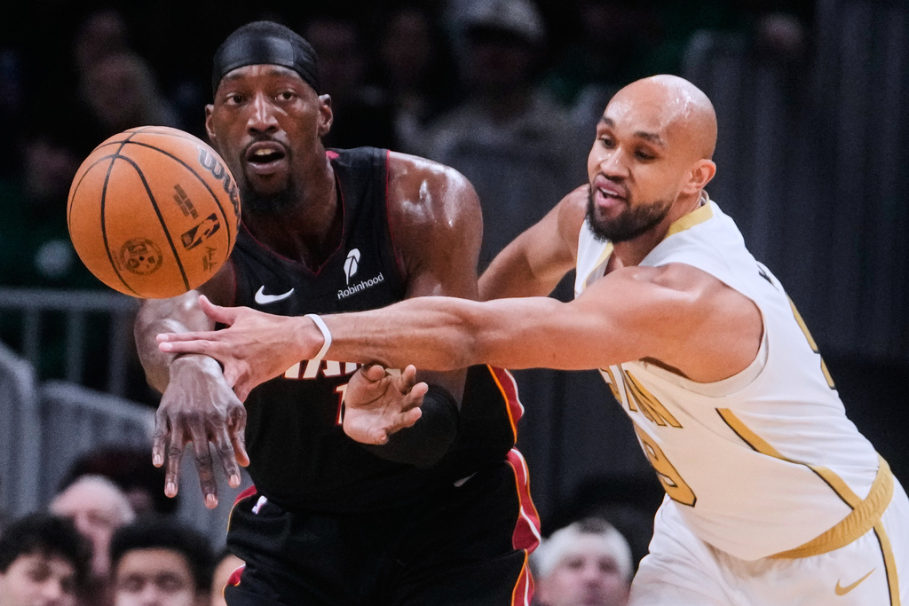 Boston Celtics guard Derrick White, right, pressures Miami Heat center Bam Adebayo, left, during the first half of an NBA basketball game, Friday, Dec. 19, 2025, in Boston. (AP Photo/Charles Krupa)