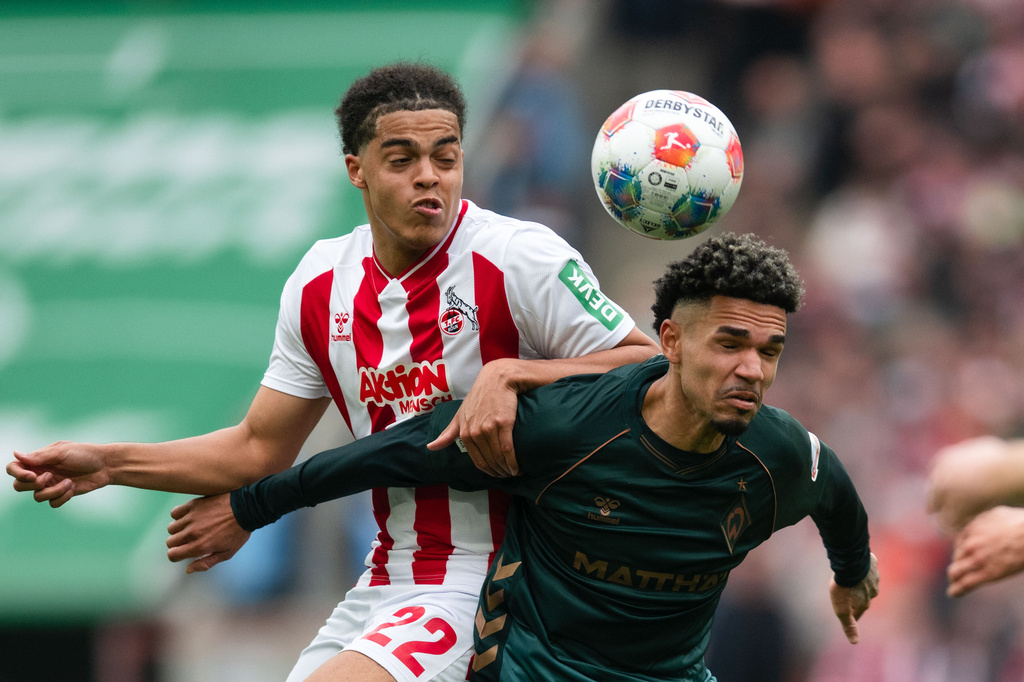 Koln's Jahmai Simpson-Pusey, left, and Werder Bremen's Justin Njinmah challenge for the ball during German Bundesliga soccer match between 1. FC Koln and Werder Bremen and Werder Bremen, in Cologne, Germany, Sunday, April 12, 2026. (Marius Becker/dpa via AP)