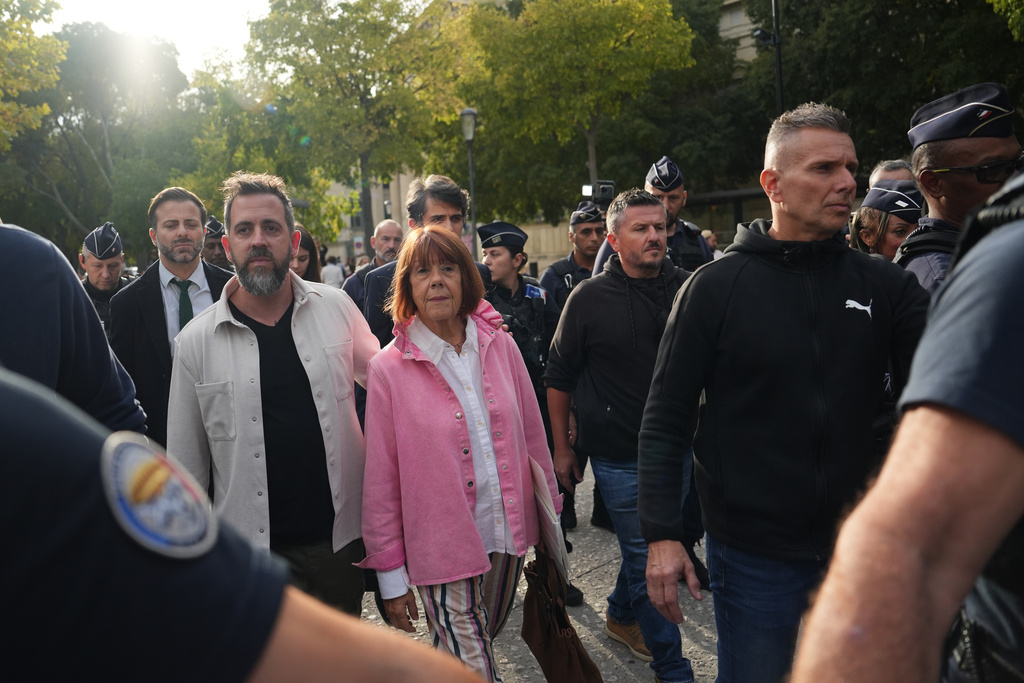 Gisele Pelicot and her son Florian Pelicot, left, leave the courthouse during the appeals trial in the case of a man challenging his conviction, less than a year after the landmark verdict in a drugging and rape trial that shook France Thursday, Oct. 9, 2025 in Nimes, southern France. (AP Photo/Lewis Joly)