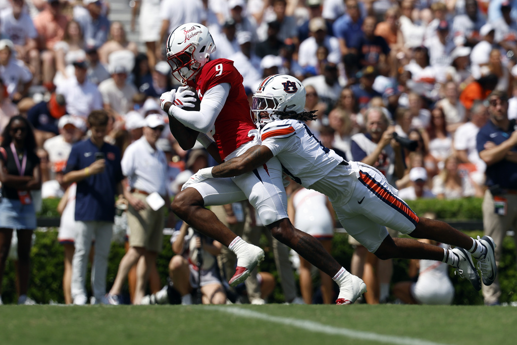South Alabama wide receiver Jeremy Scott (9) carries the ball into the end zone for a touchdown as Auburn cornerback Raion Strader (13) tries to tackle him during the first half of an NCAA college football game, Saturday, Sept. 13, 2025, in Auburn, Ala. (AP Photo/Butch Dill)
