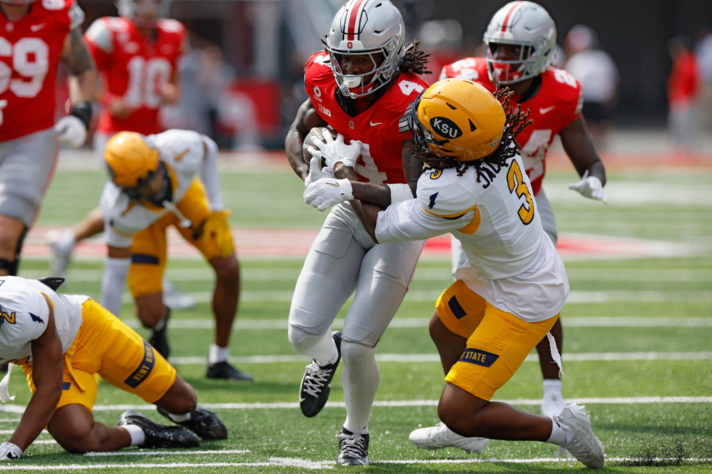 Ohio State wide receiver Jeremiah Smith, left, is tackled by Kent State defensive back Derrick Jackson during the first half of an NCAA college football game, Saturday, Sept. 19, 2026, in Columbus, Ohio. (AP Photo/Jay LaPrete)