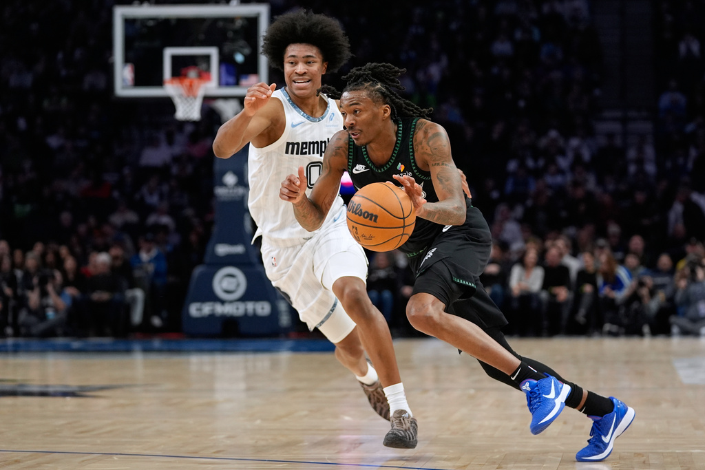 Minnesota Timberwolves guard Bones Hyland (8) works toward the basket as Memphis Grizzlies forward Jaylen Wells (0) defends during the first half of an NBA basketball game, Wednesday, Dec. 17, 2025, in Minneapolis. (AP Photo/Abbie Parr)