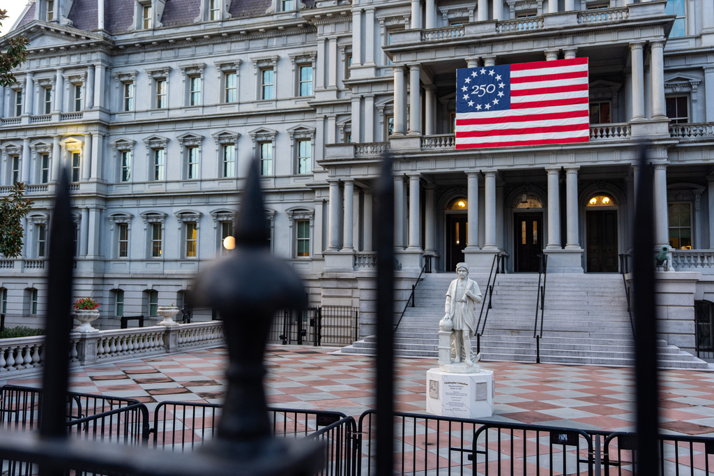 A statue of Christopher Columbus is seen in front of the Eisenhower Executive Office Building on the White House campus, Friday, Oct. 9, 2026, in Washington. (AP Photo/Alex Brandon)