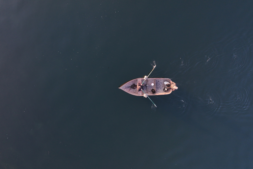 People cross the Euphrates River by boat in Raqqa, Syria, Sunday, Jan. 25, 2026. (AP Photo/Ghaith Alsayed)