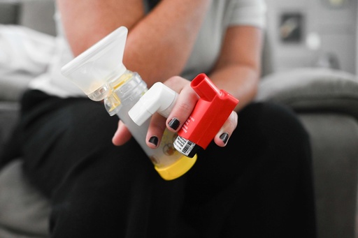 Jennifer Bittner holds her 6-year-old daughter Amelia's inhaler as she puts on her vibrating CPT vest at her home on Wednesday, Oct. 29, 2025, in Pflugerville, Texas. Amelia is a carrier for cystic fibrosis, so the vest helps break up and clear fluid from her lungs and chest. (AP Photo/Jack Myer) Jennifer Bittner holds her 6-year-old daughter Amelia's inhaler as she puts on her vibrating CPT vest at her home on Wednesday, Oct. 29, 2025, in Pflugerville, Texas. Amelia is a carrier for cystic fibrosis, so the vest helps break up and clear fluid from her lungs and chest. (AP Photo/Jack Myer)