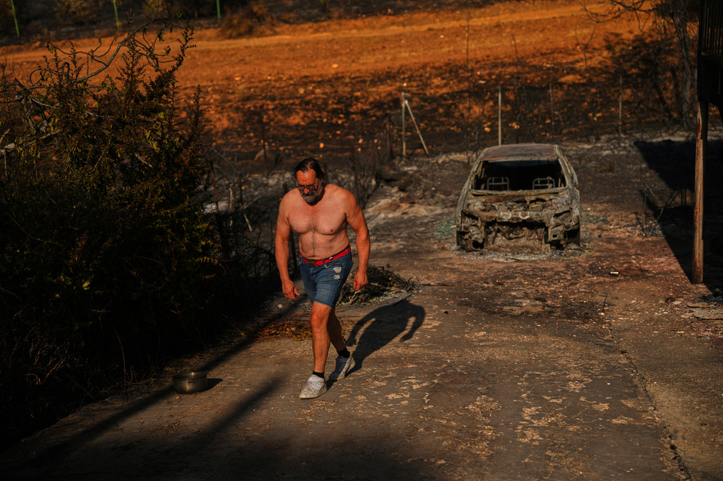 Julian Alonso walks on his property destroyed by a wildfire in El Encinar del Alberche, Madrid province, Spain, Thursday, July 30, 2026. (AP Photo/Manu Fernandez)