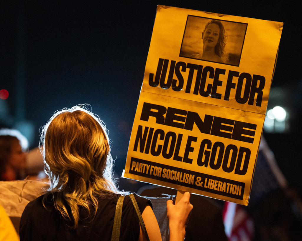 A woman holds a sign memorializing Renee Good as activists protest outside an ICE facility in Pflugerville, Texas, requesting the organization to leave the county, Thursday, Jan. 8, 2026, in solidarity with nationwide protests after the killing of U.S. citizen Renee Good by ICE agents in Minneapolis on Wednesday. (Mikala Compton/Austin American-Statesman via AP)