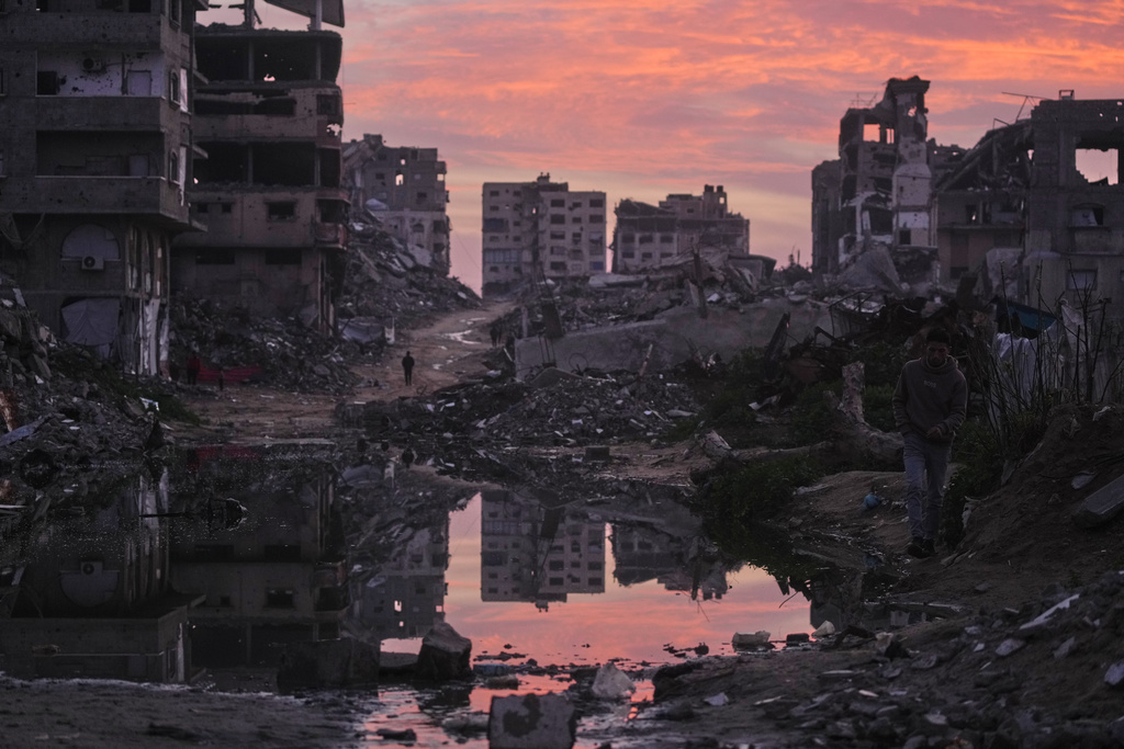 Palestinians walk amid buildings destroyed by Israeli air and ground operations in Gaza City, Thursday, Jan. 29, 2026. (AP Photo/Jehad Alshrafi)