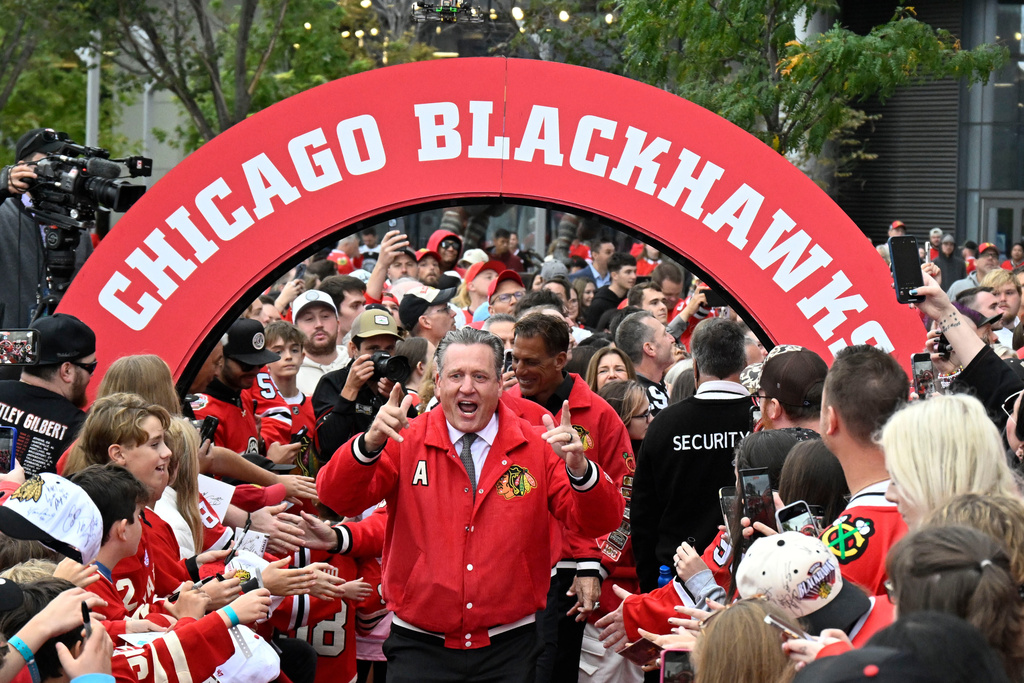 Former Chicago Blackhawks player Jeremy Roenick gestures to fans while walking on a red carpet before an NHL hockey game against the Montreal Canadiens, Saturday, Oct. 11, 2025, in Chicago. (AP Photo/Matt Marton)