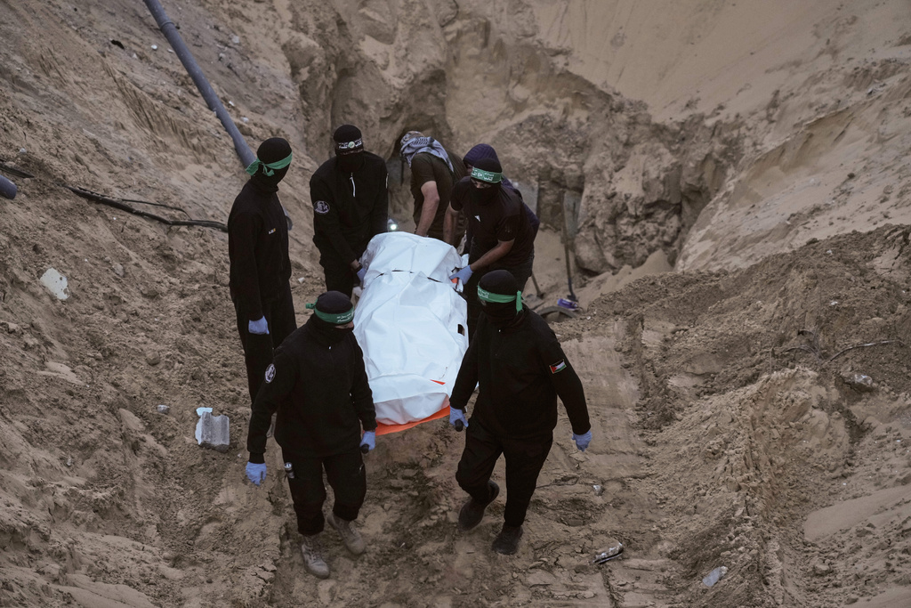 FILE - Hamas militants carry a white bag believed to contain a body, after retrieving it from a tunnel during a search for the remains of hostages in Hamad City, Khan Younis, in southern Gaza, Tuesday, Oct. 28, 2025. (AP Photo/Jehad Alshrafi, File)
