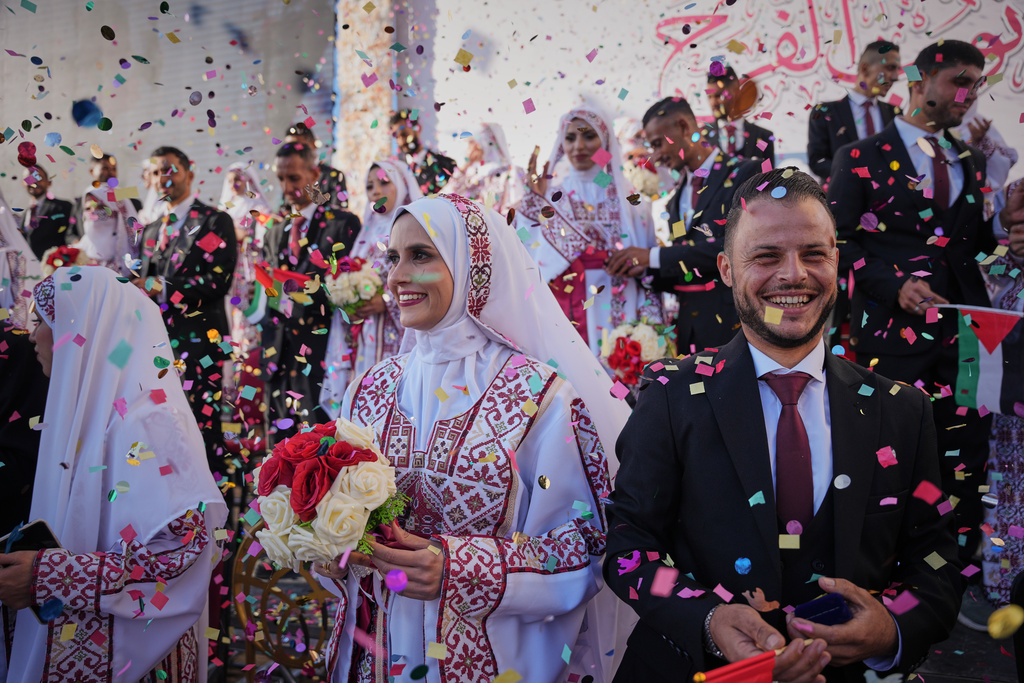 Palestinian couples participate in a mass wedding ceremony in Hamad City in Khan Younis, Gaza Strip, Tuesday, Dec. 2, 2025. (AP Photo/Abdel Kareem Hana)