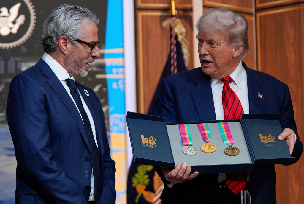 FILE - President Donald Trump listens as Casey Wasserman, chairman of LA28, presents him a full set of medals from the 1984 Olympics in Los Angeles, during an event regarding the 2028 Los Angeles Olympic Games, in the South Court Auditorium of the Eisenhower Executive Office Building on the White House campus, Tuesday, Aug. 5, 2025, in Washington. (AP Photo/Julia Demaree Nikhinson, File)
