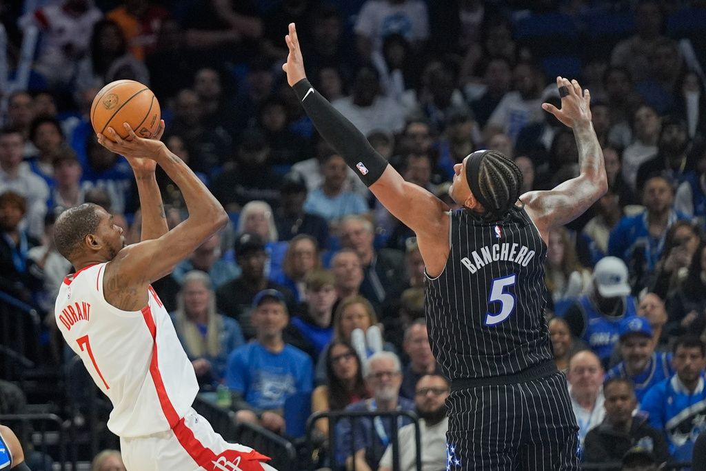 Houston Rockets forward Kevin Durant, left, shoots over Orlando Magic forward Paolo Banchero (5) during the first half of an NBA basketball game, Thursday, Feb. 26, 2026, in Orlando, Fla. (AP Photo/John Raoux)