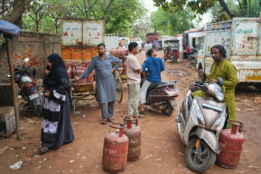 FILE- People wait with LPG gas cylinders outside a depot in New Delhi, Thursday, March 19, 2026. (AP Photo/Manish Swarup, File)