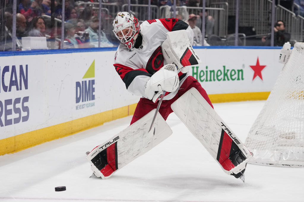 Carolina Hurricanes goaltender Brandon Bussi (32) clears the puck during the second period of an NHL hockey game against the New York Islanders Tuesday, April 14, 2026, in Elmont, N.Y. (AP Photo/Frank Franklin II)