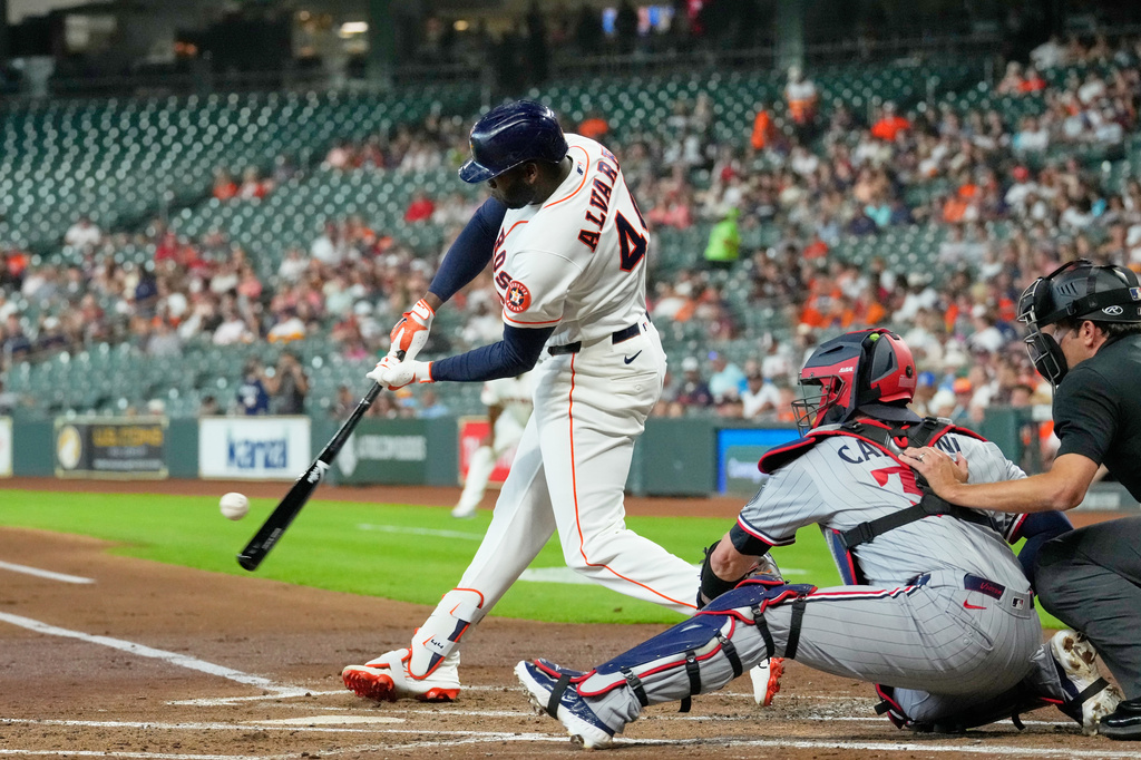Houston Astros' Yordan Alvarez (44) hits a single as Minnesota Twins catcher Victor Caratini reaches for the pitch during the first inning of a baseball game Tuesday, June 30, 2026, in Houston. (AP Photo/David J. Phillip)