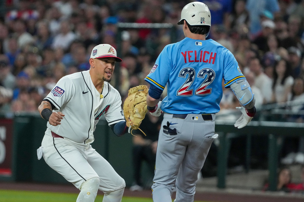 Arizona Diamondbacks first baseman Ildemaro Vargas, left, waits to tag out Milwaukee Brewers Christian Yelich (22) during the first inning of a baseball game Saturday, July 4, 2026, in Phoenix. (AP Photo/Darryl Webb)
