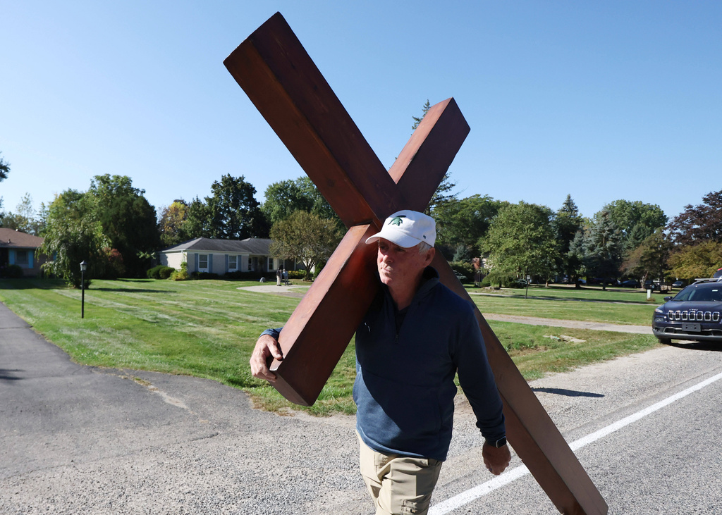 Dan Beazley carries his 10-foot-cross to the Church of Jesus Christ of Latter-day Saints, Monday, Sept. 29, 2025 in Grand Blanc Township, Mich. (AP Photo/Carlos Osorio)