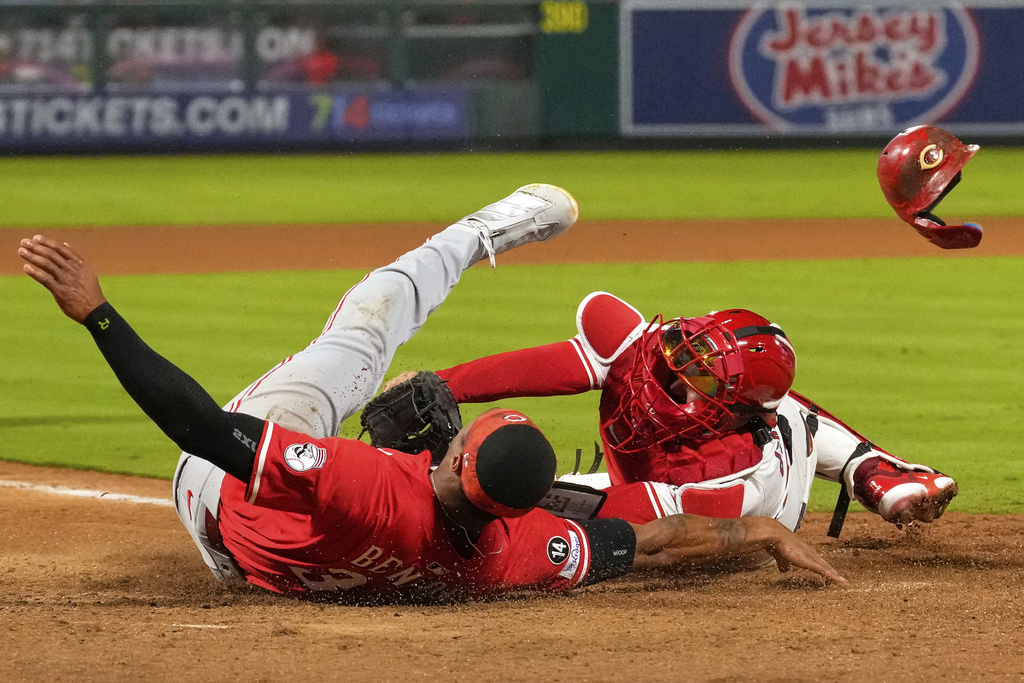 Cincinnati Reds' Will Benson, left, is tagged out by Los Angeles Angels catcher Travis d'Arnaud while trying to score on a double by Gavin Lux during the ninth inning of a baseball game Tuesday, Aug. 19, 2025, in Anaheim, Calif. (AP Photo/Mark J. Terrill)