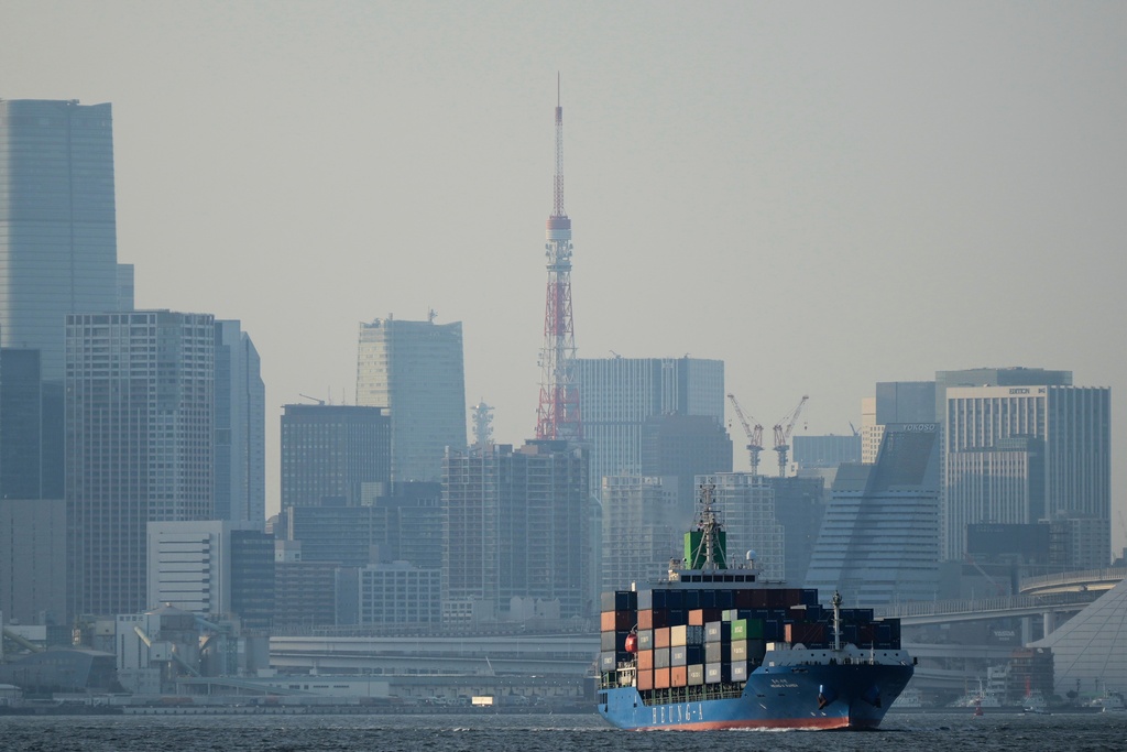 FILE - Tokyo Tower is visible amid tall buildings as a container ship leaves a cargo terminal in Tokyo, April 9, 2025. (AP Photo/Hiro Komae, File)