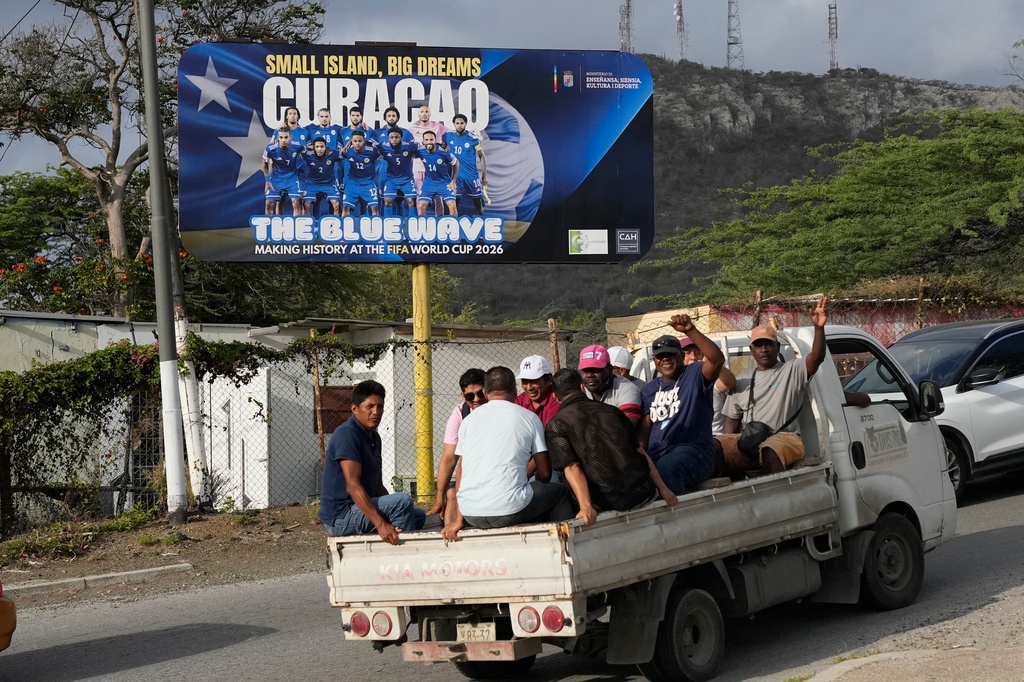 Commuters drive past a billboard displaying the Curacao national soccer team in Willemstad, Curacao, Friday, May 15, 2026. (AP Photo/Matias Delacroix)