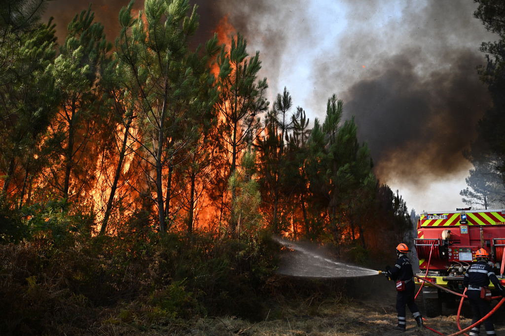 Firefighters work to extinguish a fire in the forest near Blagon, during wildfires in southwestern France, Wednesday, July 29, 2026. (AP Photo/Emma Da Silva)
