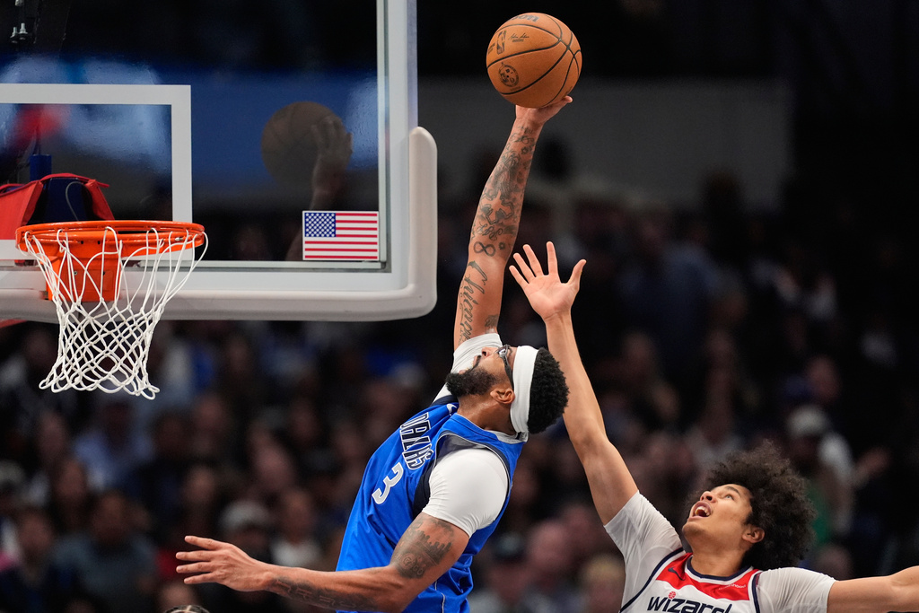 Dallas Mavericks forward Anthony Davis (3) grabs a rebound over Washington Wizards forward Kyshawn George, right, in the second half of an NBA basketball game, Friday, Oct. 24, 2025, in Dallas. (AP Photo/Tony Gutierrez)