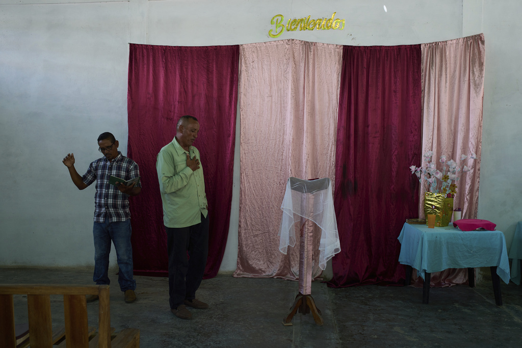 Worshippers attend a service at an evangelical church in the fishing community of El Morro de Puerto Santo, on Venezuela's Paria Peninsula, Sunday, Sept. 14, 2025. (AP Photo/Ariana Cubillos)