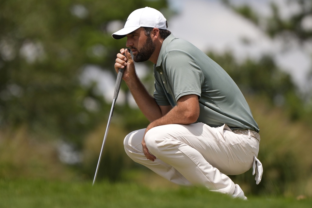 Scottie Scheffler lines up a putt on the third green during the final round of the Tour Championship golf tournament, Sunday, Aug. 24, 2025, in Atlanta. (AP Photo/Mike Stewart)