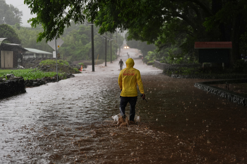 Fire Captain Lui Sales of the Hawaii Fire Department looks for residents to help as rainwater from nearby Hurricane Nolo flood a section of Mamalahoa highway Saturday, Sept. 26, 2026, near Naalehu, Hawaii. (AP Photo/Gregory Bull)