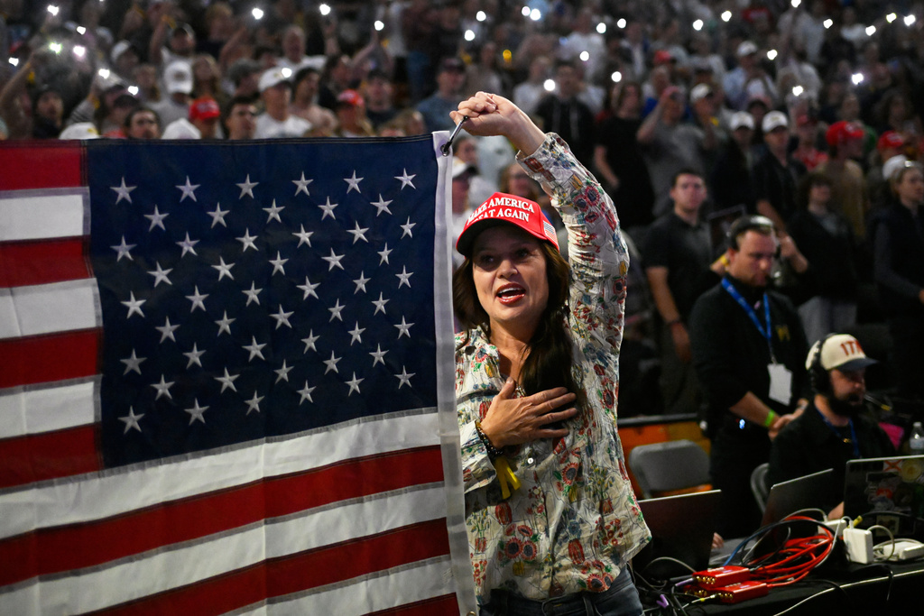 An attendee holds an American flag during a Turning Point USA rally at Utah State University, as a part of the organization's push to memorialize Charlie Kirk, Tuesday, Sept. 30, 2025, in Logan, Utah. (AP Photo/Alex Goodlett)