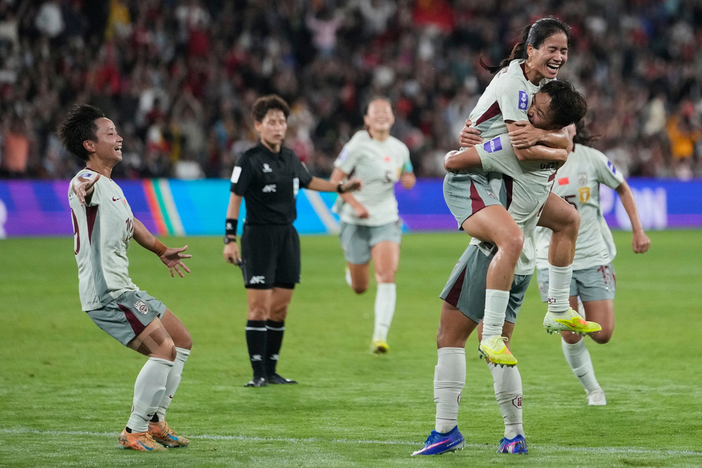 China's Chen Qiaozhu, top, celebrates with her teammates after scoring her team's first goal during the Women's Asian Cup soccer match between China and North Korea in Sydney, Monday, March 9, 2026. (AP Photo/Rick Rycroft)