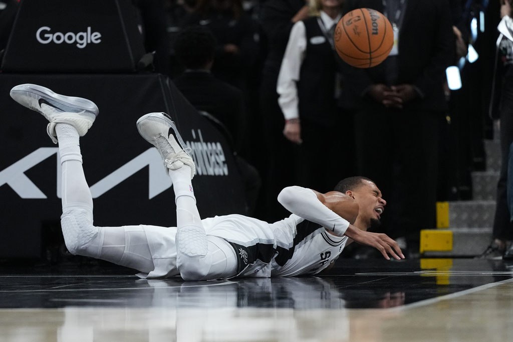 San Antonio Spurs forward Victor Wembanyama (1) takes a hard fall on the court during the first half in Game 2 of a first-round NBA playoffs basketball series against the Portland Trail Blazers in San Antonio, Tuesday, April 21, 2026. (AP Photo/Eric Gay)