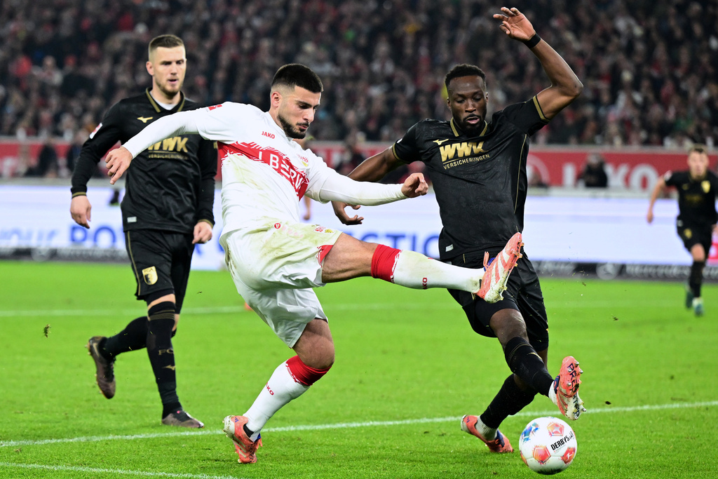 Augsburg's Chrislain Matsima, right, and Stuttgart's Deniz Undav, left, challenge for the ball during the German Bundesliga soccer match between VfB Stuttgart and FC Augsburg in Stuttgart, Germany, Sunday, Nov. 9, 2025. (Bernd Weissbrod/dpa via AP)