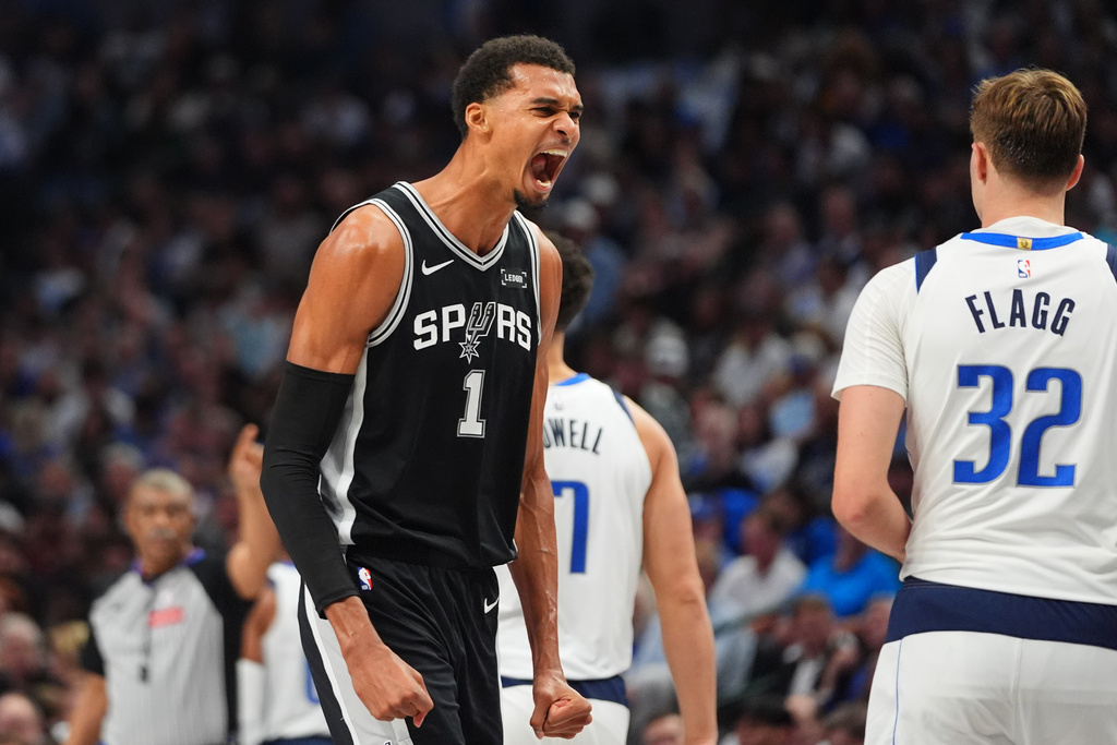 San Antonio Spurs forward Victor Wembanyama (1) reacts near Dallas Mavericks forward Cooper Flagg (32) during the first half of an NBA basketball game in Dallas, Wednesday, Oct. 22, 2025. (AP Photo/LM Otero)