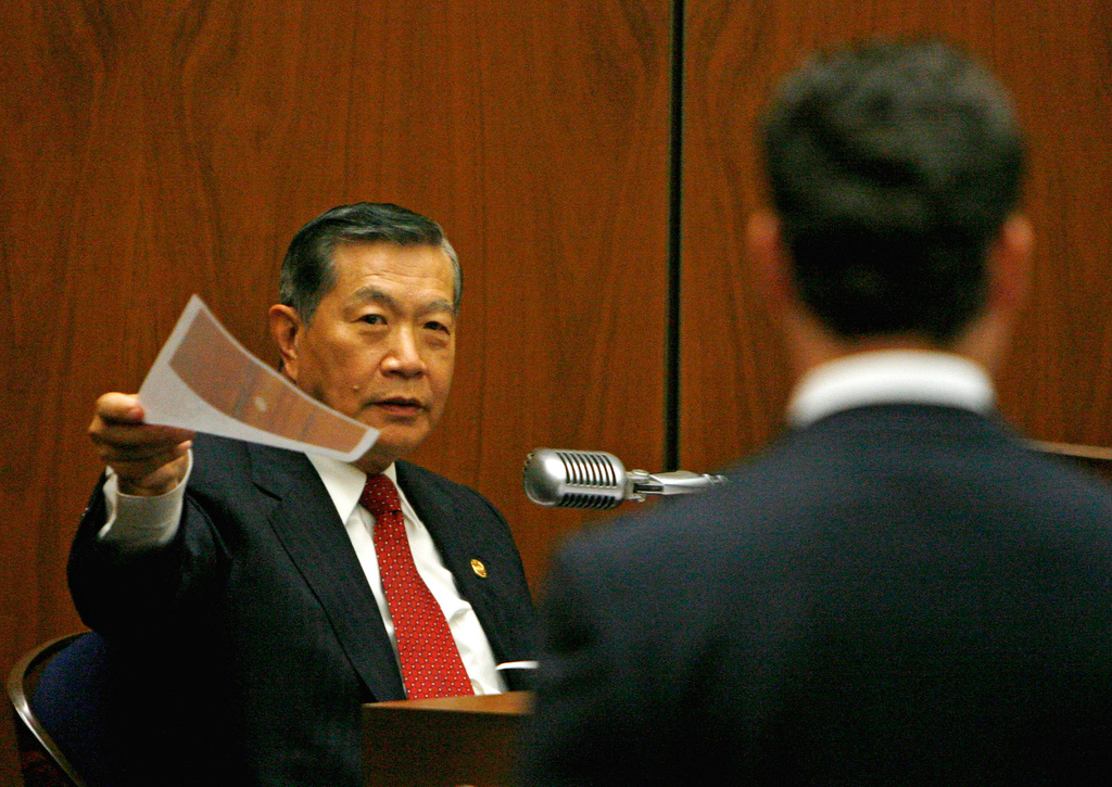 FILE - Forensic scientist Henry Lee, left, reviews photographs of evidence as prosecutor Alan Jackson waits during the murder trial of music producer Phil Spector, May 16, 2007, in Los Angeles. (AP Photo/Paul Buck, Pool, File)