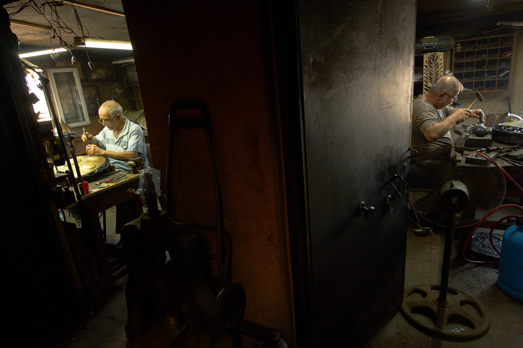 Master craftsmen specializing in inlay and relief work, Nejat Kilic, right, and Halit Cakar work in their workshop in Istanbul's Eminonu commercial district, Thursday, Aug. 6, 2026. (AP Photo/Francisco Seco)
