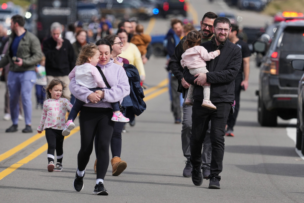 Law enforcement escort families with children away from the Temple Israel synagogue Thursday, March 12, 2026, in West Bloomfield Township, Mich. (AP Photo/Paul Sancya)