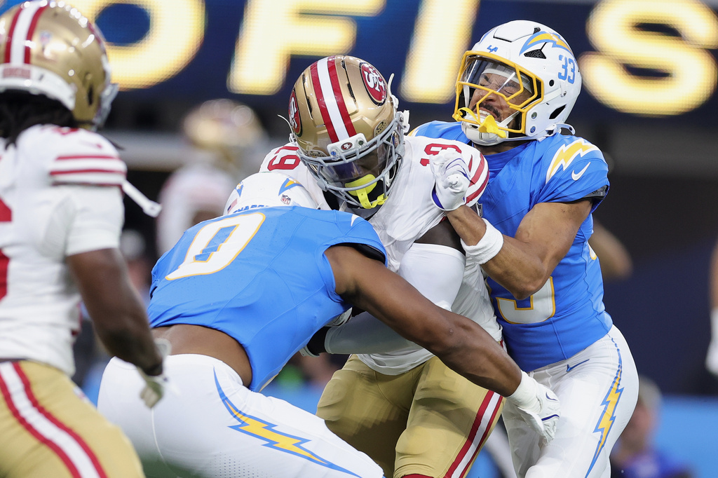 San Francisco 49ers wide receiver Deebo Samuel Sr., middle, is tackled by Los Angeles Chargers linebacker Daiyan Henley (0) and defensive back Deane Leonard (33) during the first half of a preseason NFL football game, Thursday, Aug. 20, 2026, in Inglewood, Calif. (AP Photo/Ryan Sun)