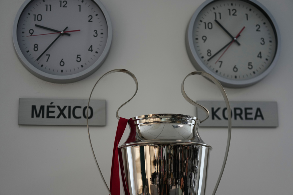 A replica of the UEFA Champions trophy is displayed next to clocks with the local time and Korea time at the Kia motors headquarters in Pesqueria, Mexico, Tuesday, March 31, 2026. (APPhoto/Fernando Llano)