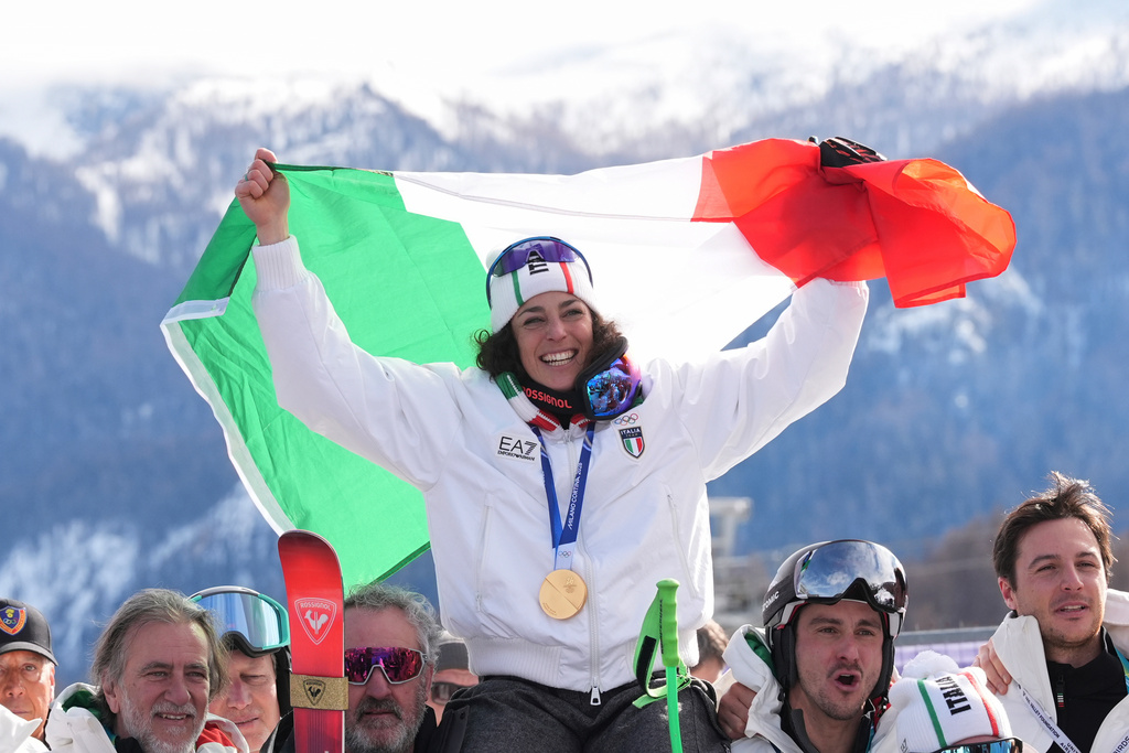 Italy's Federica Brignone celebrates winning the gold medal in an alpine ski, women's super-G race, with the team, at the 2026 Winter Olympics, in Cortina d'Ampezzo, Italy, Thursday, Feb. 12, 2026. (AP Photo/Jacquelyn Martin)