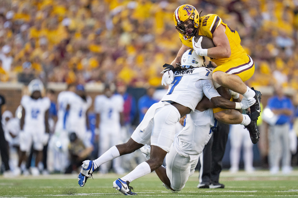 Minnesota tight end Jameson Geers (86) tries to jump over Buffalo cornerback Solomon Brown (7) and linebacker Dion Crawford, bottom right, after making a catch in the first quarter of an NCAA college football game in Minneapolis, Thursday, Aug. 28, 2025. (Alex Kormann/Star Tribune via AP)
